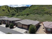 Beautiful home with a two car garage surrounded by lush green hillsides and trees at 6945 N Fargo Trl, Littleton, CO 80125