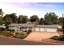 Ranch-style home featuring a three-car garage, mature landscaping, and a welcoming front porch at 6243 S Elati St, Littleton, CO 80120