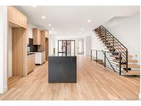 Modern kitchen featuring an island, sleek countertops, and light wood cabinets at 4303 Osceola St, Denver, CO 80212