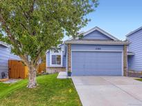 Charming blue home features a two-car garage, well-manicured lawn, and a beautiful mature tree at 11582 Depew Ct, Westminster, CO 80020