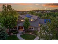 Stunning two-story home with professional landscaping and solar panels against a colorful twilight sky at 24965 E Roxbury Pl, Aurora, CO 80016