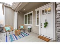 Inviting front porch with charming seating and decor, perfect for relaxing outdoors at 6657 S Kline Way, Littleton, CO 80127