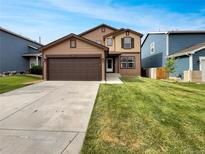 Two-story home boasts a well-manicured lawn and a two-car garage, offering both curb appeal and functionality at 16453 E Phillips Dr, Englewood, CO 80112