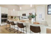 Bright kitchen features a large island with barstool seating and stainless steel appliances at 1060 Marfell St, Erie, CO 80516