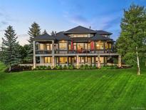 Stunning multi-story home featuring a spacious porch and beautifully landscaped yard with mature trees at 5602 Silver Bluff Ct, Parker, CO 80134