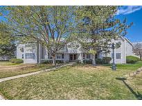 Inviting townhome complex with well-maintained landscaping and mature trees on a sunny day at 12685 E Pacific Cir # B, Aurora, CO 80014