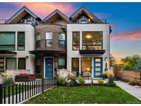 Modern three-story townhome with a landscaped front yard and teal front door at 2257 S High St, Denver, CO 80210
