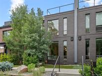 Modern brick home with striking curb appeal, featuring a rooftop deck and manicured landscaping at 3715 Kalamath St, Denver, CO 80211