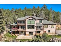 Spacious home with multiple balconies and large windows overlooking the surrounding forest and lush backyard at 9659 S Turkey Creek Rd, Morrison, CO 80465