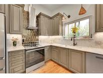 Well-lit kitchen featuring stainless steel appliances, countertops, and a stylish backsplash at 6034 S Niagara Ct, Centennial, CO 80111