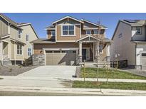 Two-story home with a two-car garage, stone accents and a well-manicured lawn at 5581 Inland Ave, Firestone, CO 80504