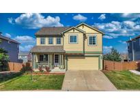 Charming two-story home with a well-manicured lawn, covered front porch, and attached two-car garage at 9767 Burberry Way, Highlands Ranch, CO 80129