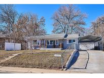 Charming single-story home with a covered carport and chain link fence at 1193 S Umatilla St, Denver, CO 80223