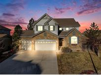 Beautiful two-story home with stone accents, a three-car garage, and a scenic twilight sky at 2636 Trailblazer Way, Castle Rock, CO 80109