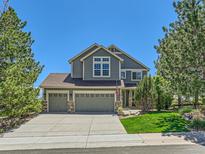 Charming two-story home boasts a three-car garage, well-maintained lawn and mature trees at 1674 Bent Grass Cir, Castle Rock, CO 80109