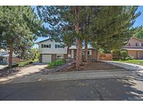 Charming two-story home featuring a stone facade, attached garage, and mature trees in a desirable neighborhood at 9350 Raleigh Ct, Westminster, CO 80031
