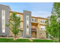 Stylish multi-level condo featuring stone accents, modern gray accents, and a charming balcony at 6745 S Tempe Ct, Aurora, CO 80016