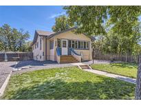 Charming home with a well-manicured lawn, complemented by blue trim and natural accents at 3280 Fenton St, Wheat Ridge, CO 80212