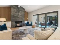 Bright living room with fireplace, wood accents, and sliding glass doors to outdoor patio at 2552 E Alameda Ave # 92, Denver, CO 80209