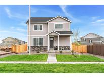 Two-story house with gray siding, stone accents, and a landscaped lawn at 22293 E 6Th Pl, Aurora, CO 80018