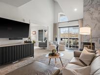 Open-concept living room featuring high ceilings, a modern fireplace, and a large window overlooking the neighborhood at 345 Fillmore St # 407, Denver, CO 80206