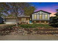 Charming two-story home with a manicured lawn, rock garden, blue front door, and a spacious two-car garage at 1309 Alexandria St, Lafayette, CO 80026