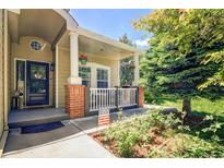 Inviting front porch with classic columns and charming decor, perfect for relaxing and enjoying the neighborhood at 16084 Stonebriar Dr, Parker, CO 80134