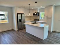 Modern kitchen with island, stainless steel appliances, and white cabinetry at 5292 Columbine Ln, Denver, CO 80221