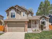 Charming two-story home with a well-maintained lawn, attached garage, and inviting front porch at 13358 Briarwood Dr, Broomfield, CO 80020