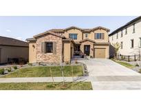 Charming two-story home with a stone facade, manicured lawn, and a welcoming front entrance at 2125 S Orion St, Lakewood, CO 80228