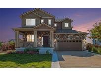Charming two-story home featuring stone accents, a covered porch, and a two-car garage at 6147 N Flanders St, Aurora, CO 80019