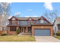 Charming two-story home featuring brick and blue siding, complemented by a well-maintained front yard and two-car garage at 16234 E Belleview Dr, Centennial, CO 80015