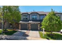 Charming townhome with stone accents, gray siding, and attached garages at 2002 E 102Nd Cir, Thornton, CO 80229