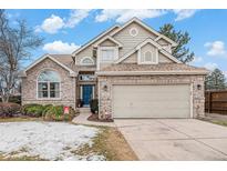 Charming brick home with a two-car garage and a well-maintained lawn and blue door at 11052 Rowland, Littleton, CO 80127