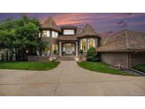 Elegant brick home features a turret-style design, manicured lawn, and a welcoming entrance, creating a grand curb appeal at 8337 Greenwood Dr, Niwot, CO 80503