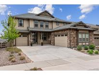 Two-story house with stone and siding exterior, two-car garage, and landscaping at 8107 Arapahoe Peak St, Littleton, CO 80125