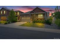 Charming two-story home with a stone facade, a two-car garage, and beautifully landscaped yard at 5741 Echo Park Cir, Castle Rock, CO 80104