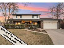 Charming two-story home featuring a well-manicured lawn, brick accents, and an attached two-car garage at 1998 S Harlan Ct, Lakewood, CO 80227