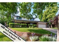 Charming two-story home features a manicured lawn, brick accents, and an attached two-car garage at 1998 S Harlan Ct, Lakewood, CO 80227