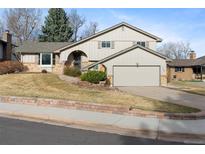 Charming two-story home with an attached two-car garage, a tidy lawn, and appealing brick accents at 3765 S Depew St, Denver, CO 80235