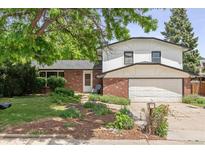 Charming two-story home with manicured front yard and attached two-car garage at 5987 W Ken Caryl Pl, Littleton, CO 80128