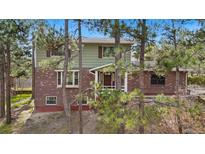 Charming two-story home with brick and siding exterior, surrounded by trees at 1185 Fawnwood Rd, Monument, CO 80132