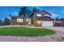 Charming two-story home boasts a well-maintained lawn, brick accents, and an attached two-car garage at 15918 E Flora Pl, Aurora, CO 80013