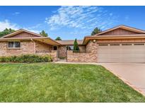 Inviting single-story home with a well-maintained lawn and brick exterior at 2180 S Flower Way, Lakewood, CO 80227