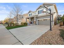 Charming two-story home features a gray exterior, a two-car garage, a well-maintained lawn, and a basketball hoop at 2198 Broadleaf Loop, Castle Rock, CO 80109