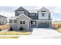 Beautiful two-story home with a stone facade and a two-car garage, enhancing its curb appeal at 14247 Beebalm Loop, Parker, CO 80134