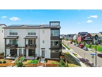 Modern townhome with solar panels, balcony, and manicured front yard at 16637 Shoshone St, Broomfield, CO 80023