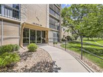 Inviting entrance to Building 209 with accessible ramp and well-maintained landscaping and stone entryway at 3124 S Wheeling Way # 102, Aurora, CO 80014