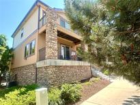 Charming multi-story home featuring a stone facade, private balcony, and well-maintained landscaping at 3155 E 104Th Ave # 4E, Thornton, CO 80233