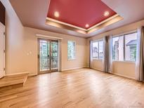 Bright living room with hardwood floors, large windows, and a unique coffered ceiling design at 3155 E 104Th Ave # 4E, Thornton, CO 80233